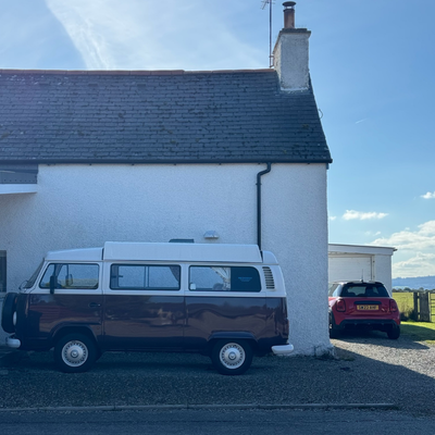 A house in Dornoch, Scotland with a van next to it.