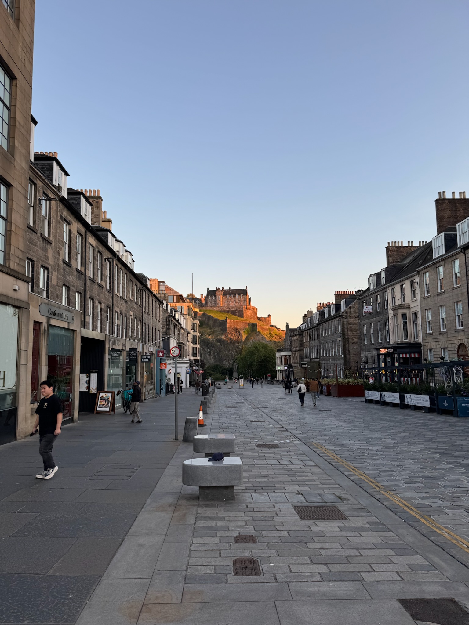 A street in Edinburgh looking up at Edinburgh castle as the sun is setting.